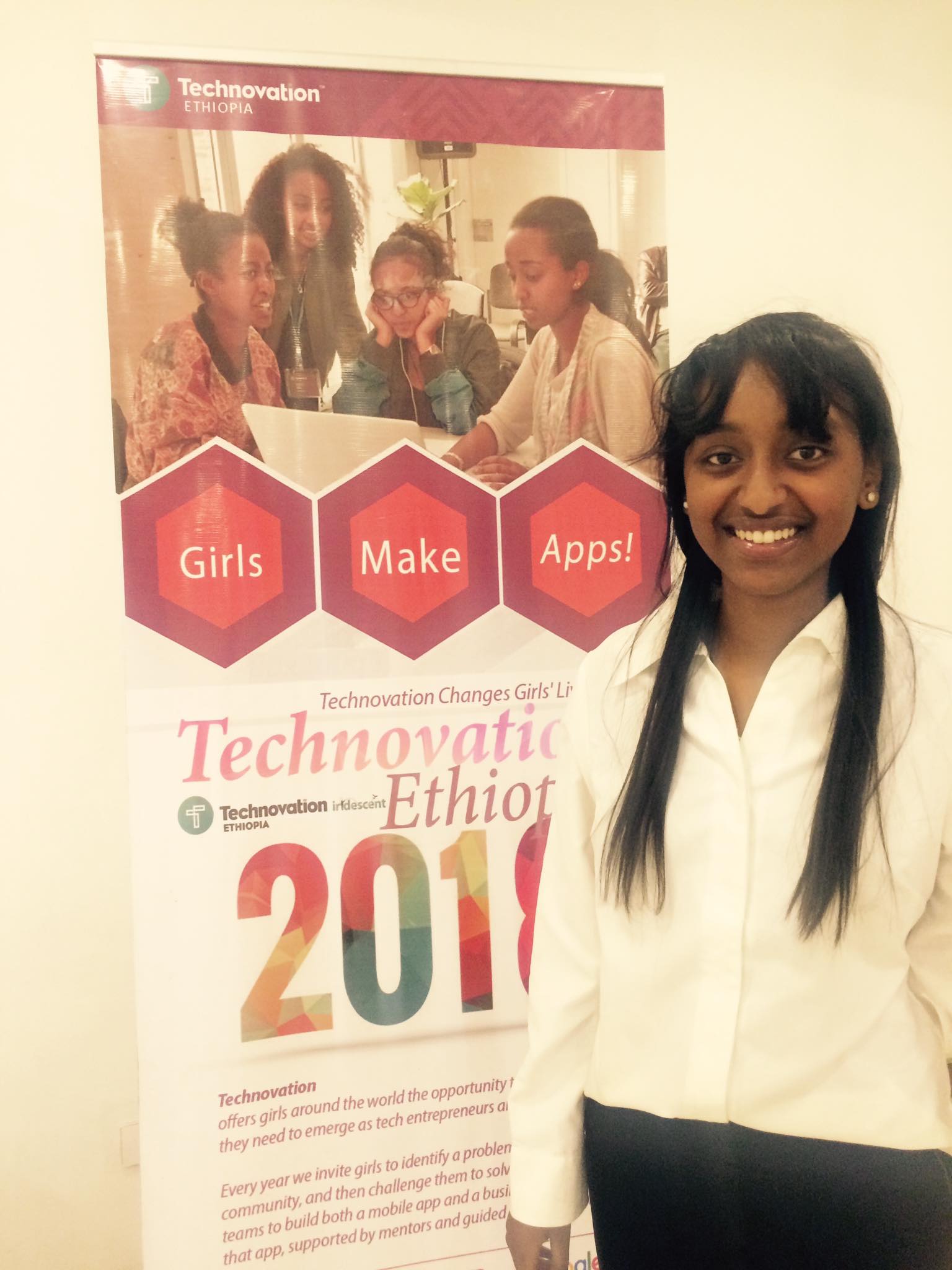 Saron Gebre at the 2018 Technovation Ethiopia competition, standing in front of the competition's poster board.